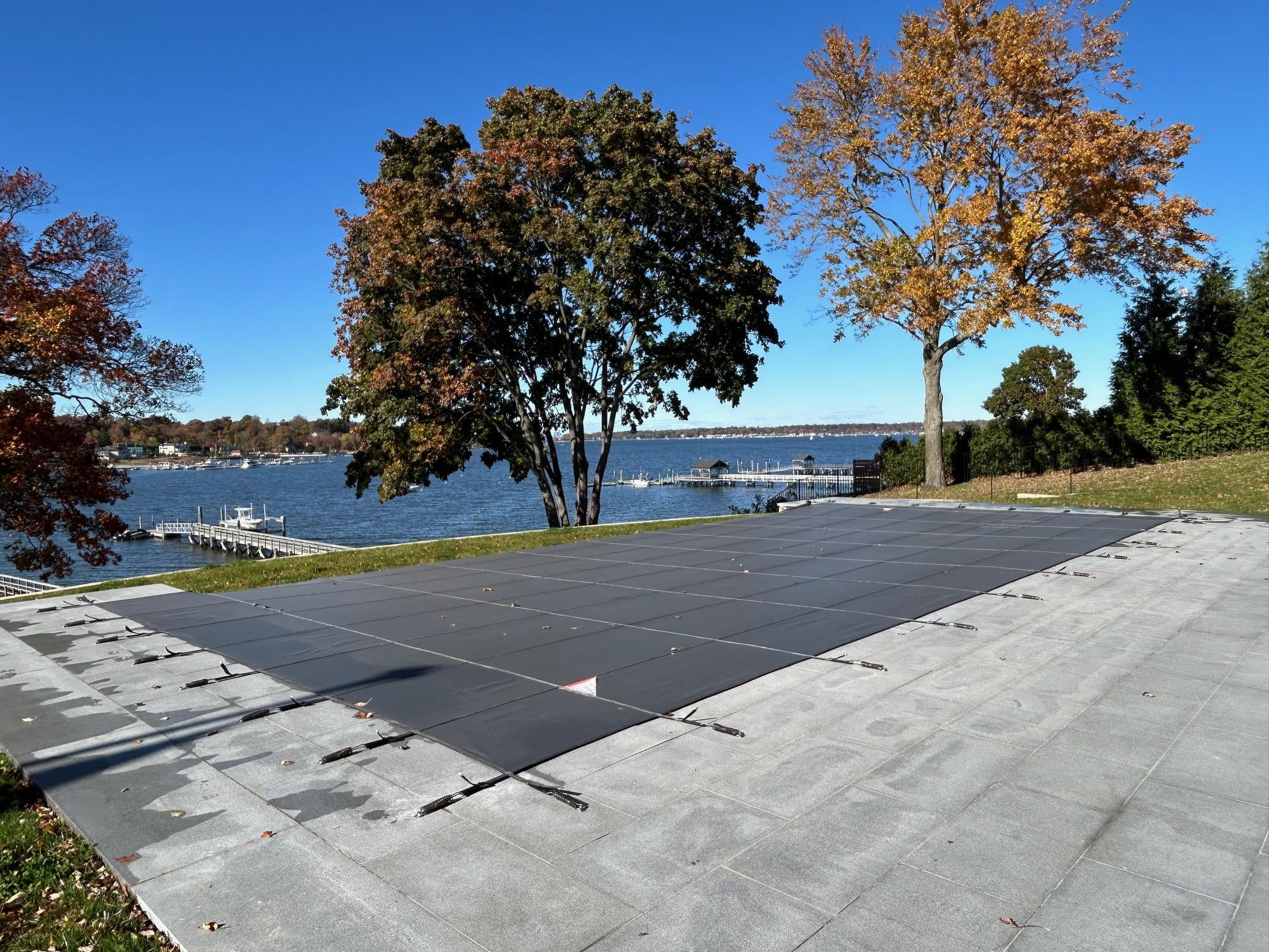 Pool with Meyco safety cover installed, lakefront in autumn
